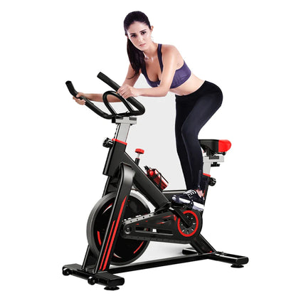 Woman exercising on a stationary bike against a white background