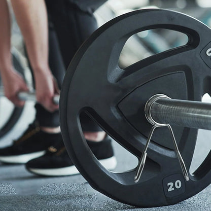 Close-up of a barbell with weight plates in a gym setting