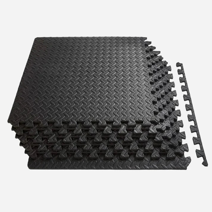 Stack of black interlocking foam mats on a white background