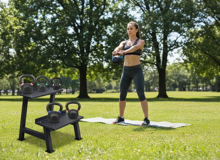 Woman exercising with kettlebells in a park setting